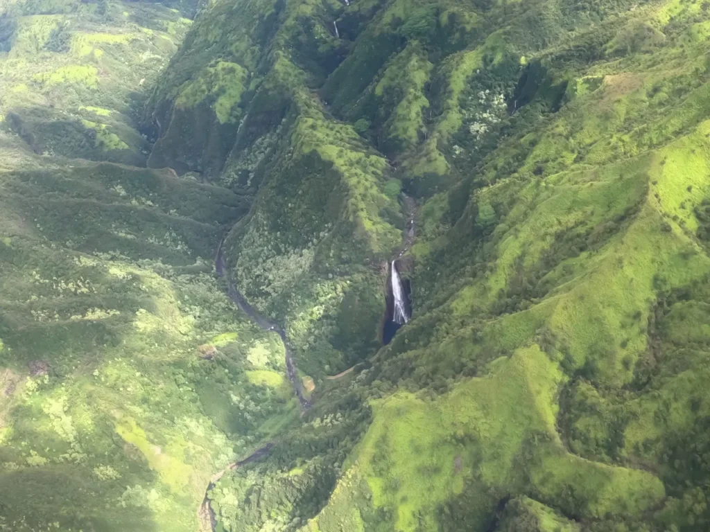 The famous Manawaiopuna Waterfalls hidden deep in the island valleys, viewed from a private air tour Kauai.