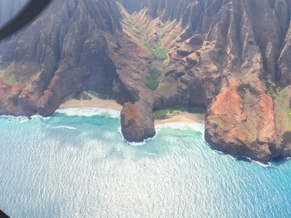Looking out the window of a small plane at the beautiful green landscape shortly after starting a private air tour Kauai.