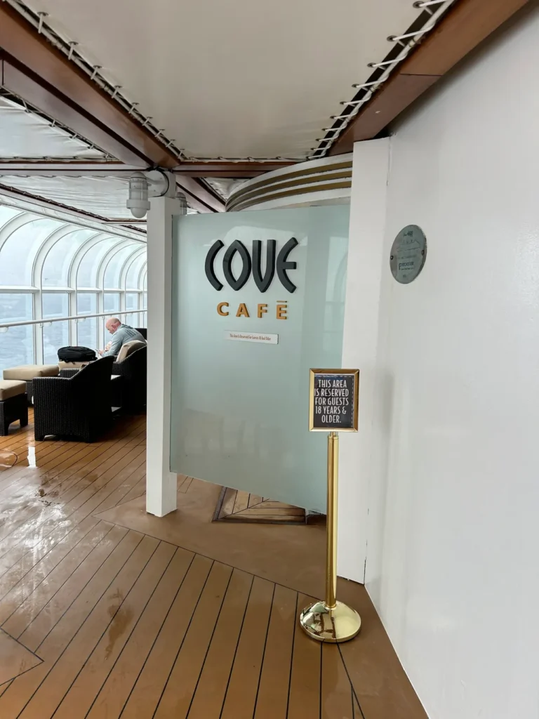 Caffeine junkies can get their fix at the Cove Cafe. In this adult only spot, you can enjoy a specialty drink or your favorite coffee or tea concoction. The frosted glass entryway and "18 years and older" marquee sign for the Cove Cafe on a Disney cruise for adults.