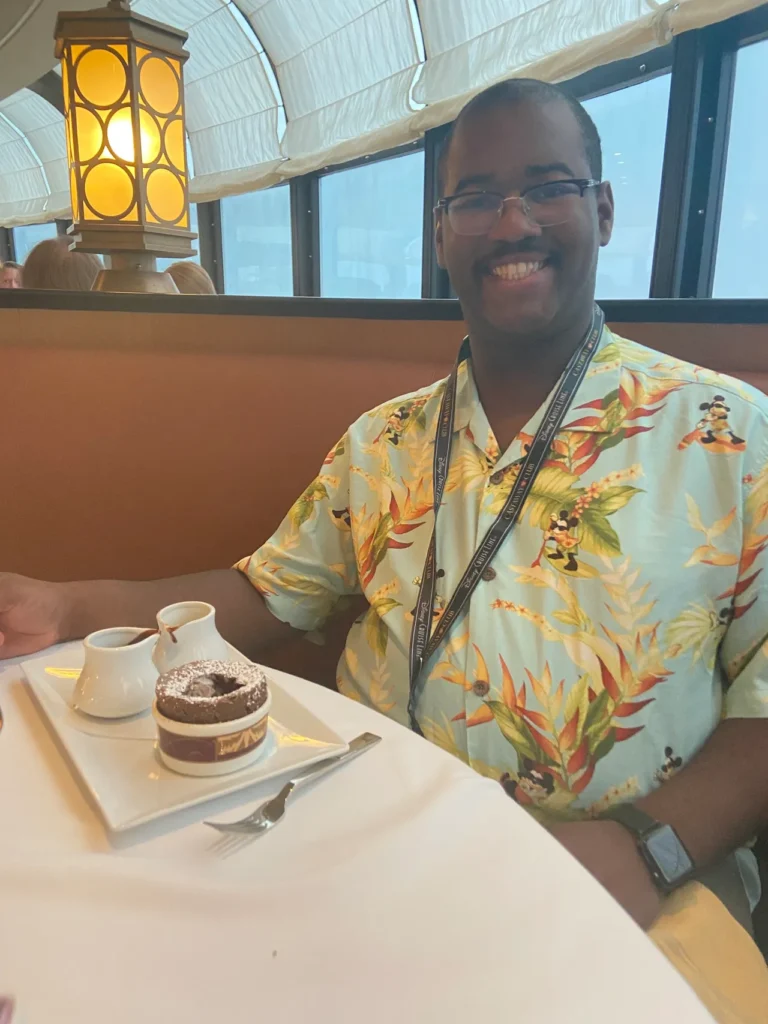 Palo Restaurant is a delicious highlight to every Disney Cruise we take. The finale of each dinner there is a chocolate souffle. Simply amazing. A guest wearing a Disney Cruise Line Castaway Club lanyard enjoying the famous chocolate soufflé at Palo restaurant on a Disney cruise for adults.