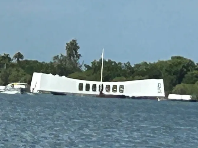 A view from shore of the USS Arizona Memorial at Pearl Harbor. A distant view from the shoreline looking out at the floating USS Arizona shrine during a visit to the Pearl Harbor Memorial Hawaii.