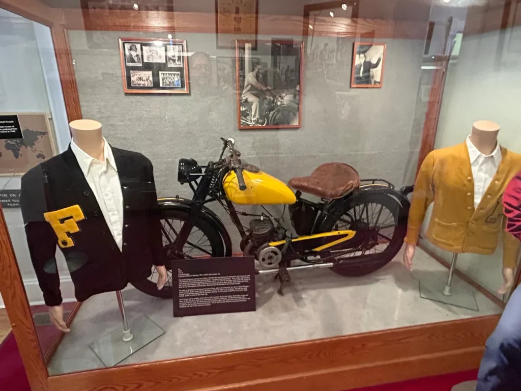 On display at the James Dean Museum is his 1947 Czech 125cc motorcycle A vintage yellow 1947 Czech 125cc motorcycle showcased inside a glass exhibit case at the James Dean Museum in Indiana.
