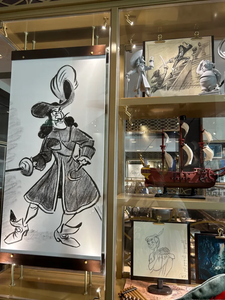 Disney sketch artwork and a Captain Hook pirate ship model inside the 1923 restaurant featured in our Disney Wish dining guide.