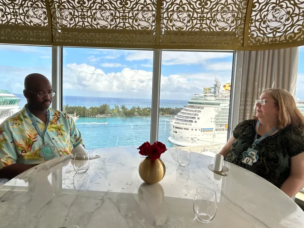 Guests enjoying an adult-only brunch with a sea view of cruise ships through the floor-to-ceiling windows at Enchanté from our Disney Wish dining guide.