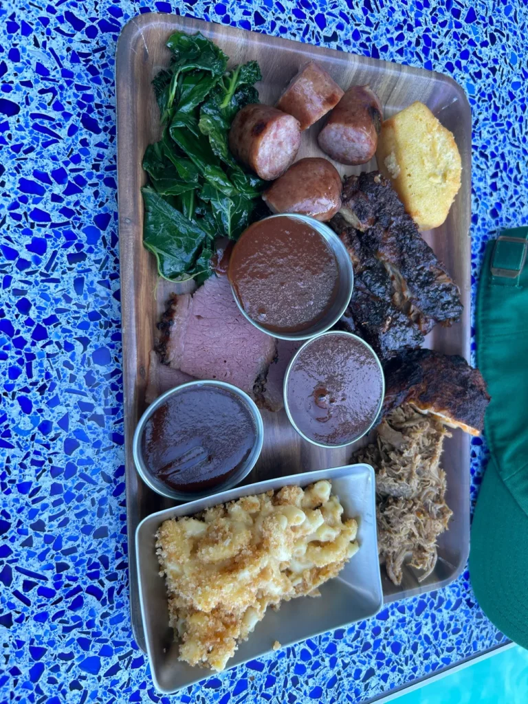 A delicious barbecue combo platter featuring smoked meats and classic sides at Mickey's Smokestack on the Disney Wish dining guide cruise ship.