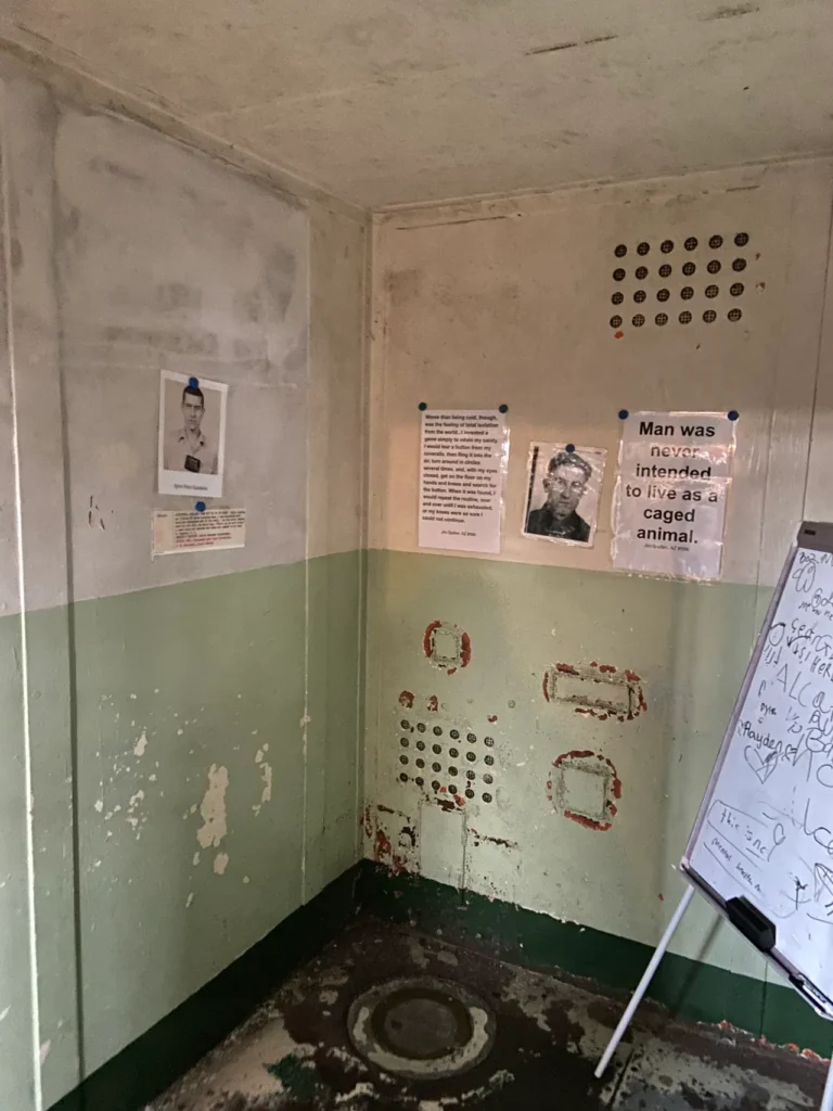 The tour of Alcatraz includes the history of the facility, as well as first hand storytelling from the prisoners who spent time incarcerated there. A look inside a small, stark standard inmate cell with a cot and desk at Alcatraz Prison San Francisco.