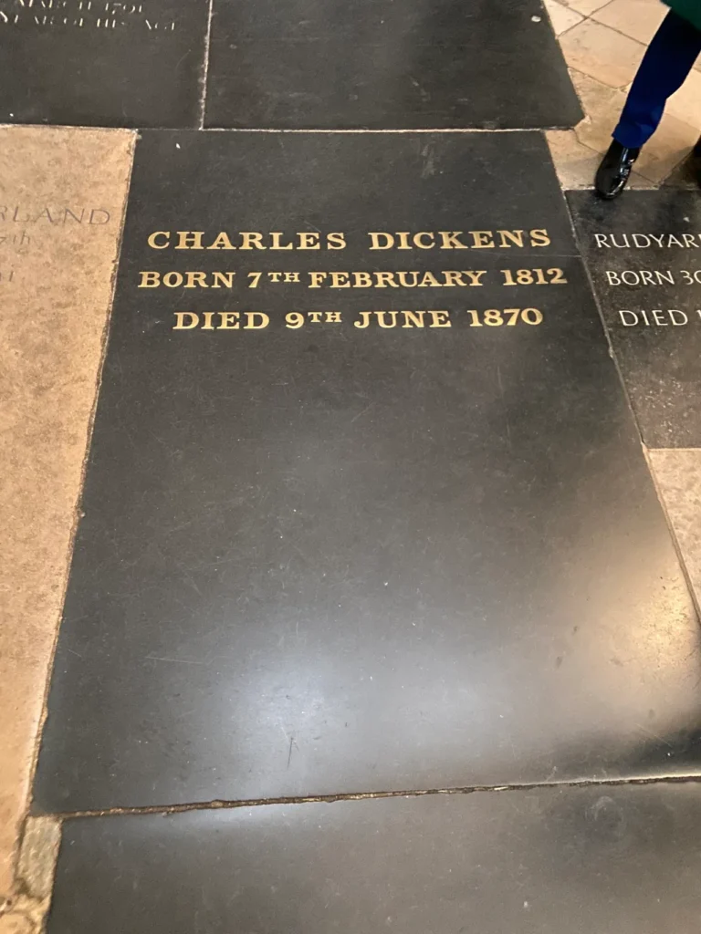 Literary giant Charles Dickens is one of the many famous graves you can visit at Westminster Abbey. The dark stone floor grave marker of literary giant Charles Dickens in Poets' Corner at Westminster Abbey London.