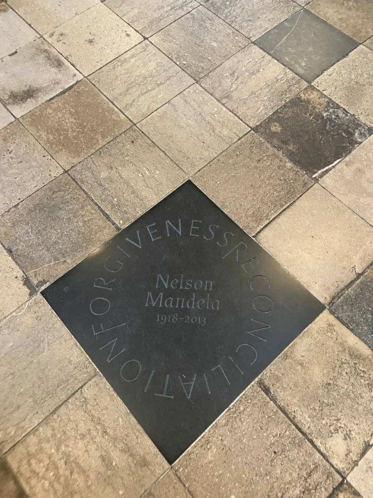 “Forgiveness Reconciliation” are the words engraved to symbolize the life of Nelson Mandela, memorialized at Westminster Abbey. The inscribed dark stone floor memorial honoring South African president Nelson Mandela at Westminster Abbey London.