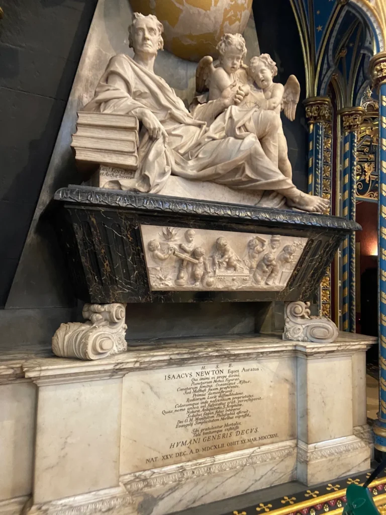 The final resting place of Sir Isaac Newton is at Westminster Abbey with an impressive display. The grand marble monument and final resting place of Sir Isaac Newton inside Westminster Abbey London.