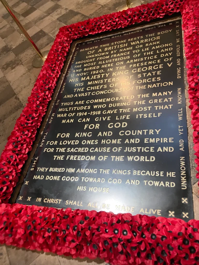 The British Tomb of the Unknown Warrior is sacred ground at Westminster Abbey. While other markers can be walked on, this specially designated grave is set aside. The sacred floor grave marker of the Tomb of the Unknown Warrior surrounded by red poppies at Westminster Abbey London.