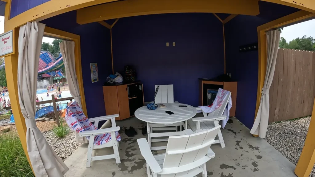 One of the basic cabanas available within Splashin Safari. Most packages include a reserved area for you and guests, a secure locker, access to electricity, a refrigerator with bottles of water. A basic rental cabana with patio seating, a secure locker, and a mini-fridge inside Splashin' Safari at Holiday World Santa Claus Indiana.