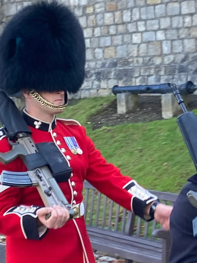 Seeing the changing of the guard ceremony at Windsor Castle offered us an up close opportunity to see it without having to fight the bigger crowds at Buckingham Palace. A close-up profile view of a British soldier wearing a ceremonial red tunic and bearskin hat during the Changing of the Guards ceremony.
