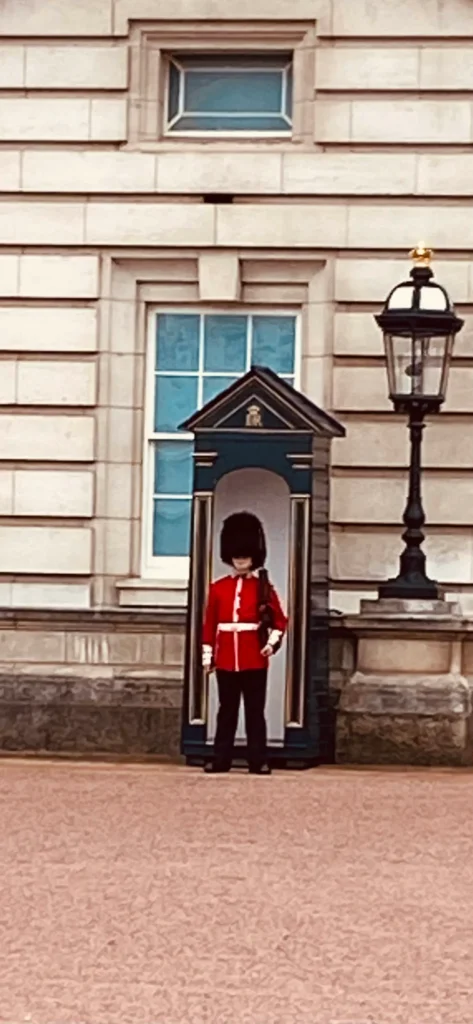 Guards on duty at Buckingham Palace. A British soldier standing at attention inside a dark green sentry box during the Changing of the Guards ceremony.