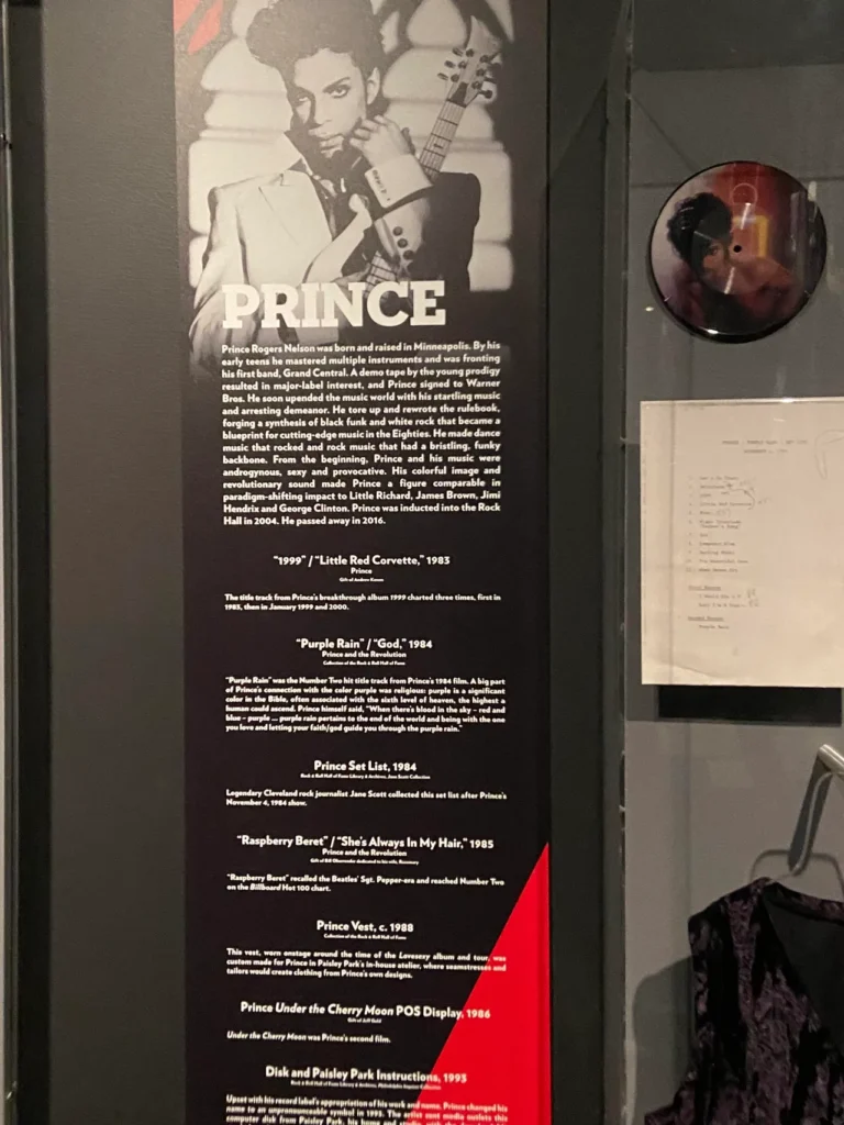 Guitars, concert worn clothing and the music of Prince are on display at the Rock and Roll Hall in Cleveland. A museum display case dedicated to Prince featuring a tribute panel, iconic vinyl record, and typed setlist at the Rock and Roll Hall of Fame Cleveland.