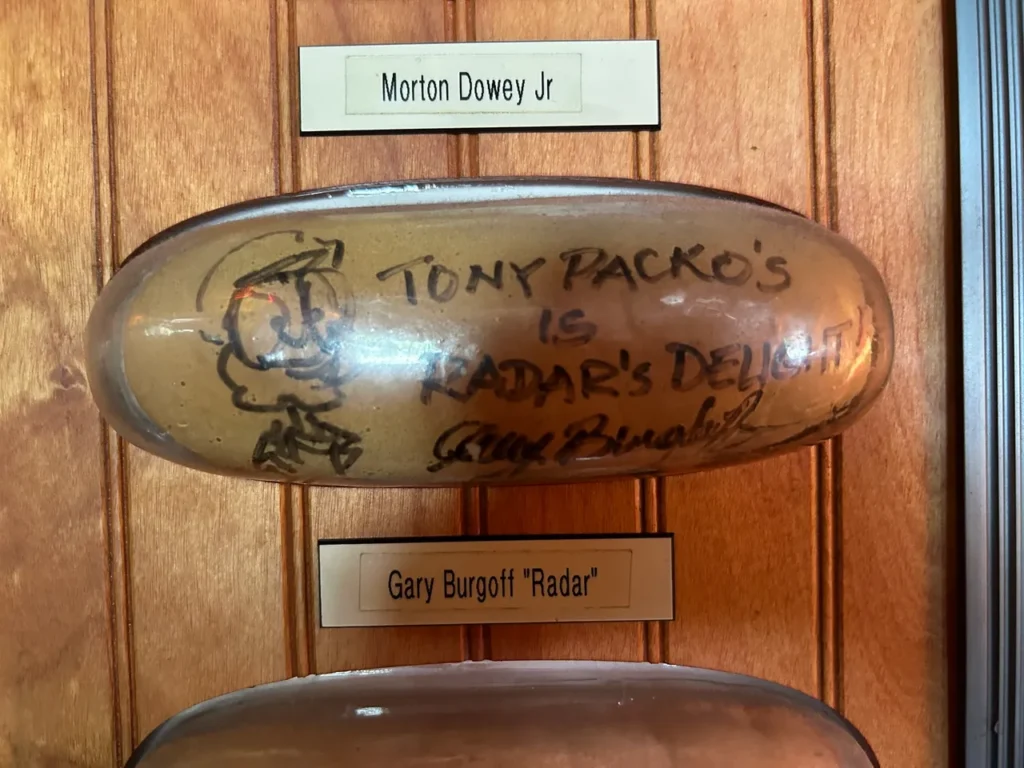 Signed hot dog buns line the wall throughout the restaurant at Tony Packo's in Toledo. They hold the World's Record for the largest collection of signed buns, which includes a who's who of celebrities including MASH star Gary Burghoff. A detailed display of celebrity autographed hot dog buns lining the walls inside Tony Packo's Toledo, a famous tradition from the restaurant.
