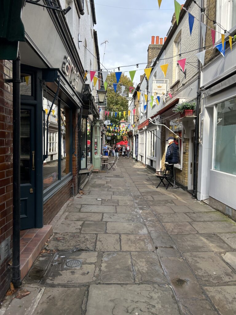 Paved Court in Richmond England Looking down the historic cobblestone alleyway of Paved Court lined with shops, a central destination in our Richmond England Ted Lasso walking guide.