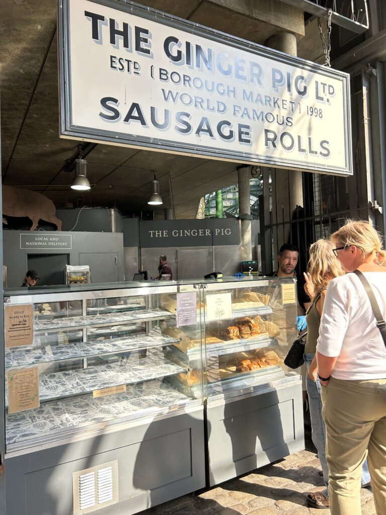 The Ginger Pig, Borough Market UK A giant gourmet sausage roll on display at The Ginger Pig butcher stall inside London's Borough Market, a top food destination.