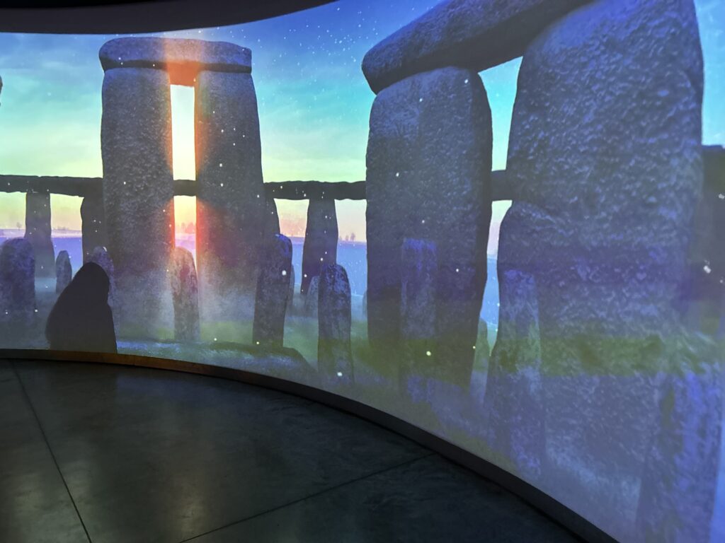 In the visitor's center, you'll learn about the specific placement of the stones and their precise locations in correlation with the winter and summer solstice. Standing inside the panoramic virtual tour exhibit at the visitor's center on a Stonehenge vacation itinerary trip.