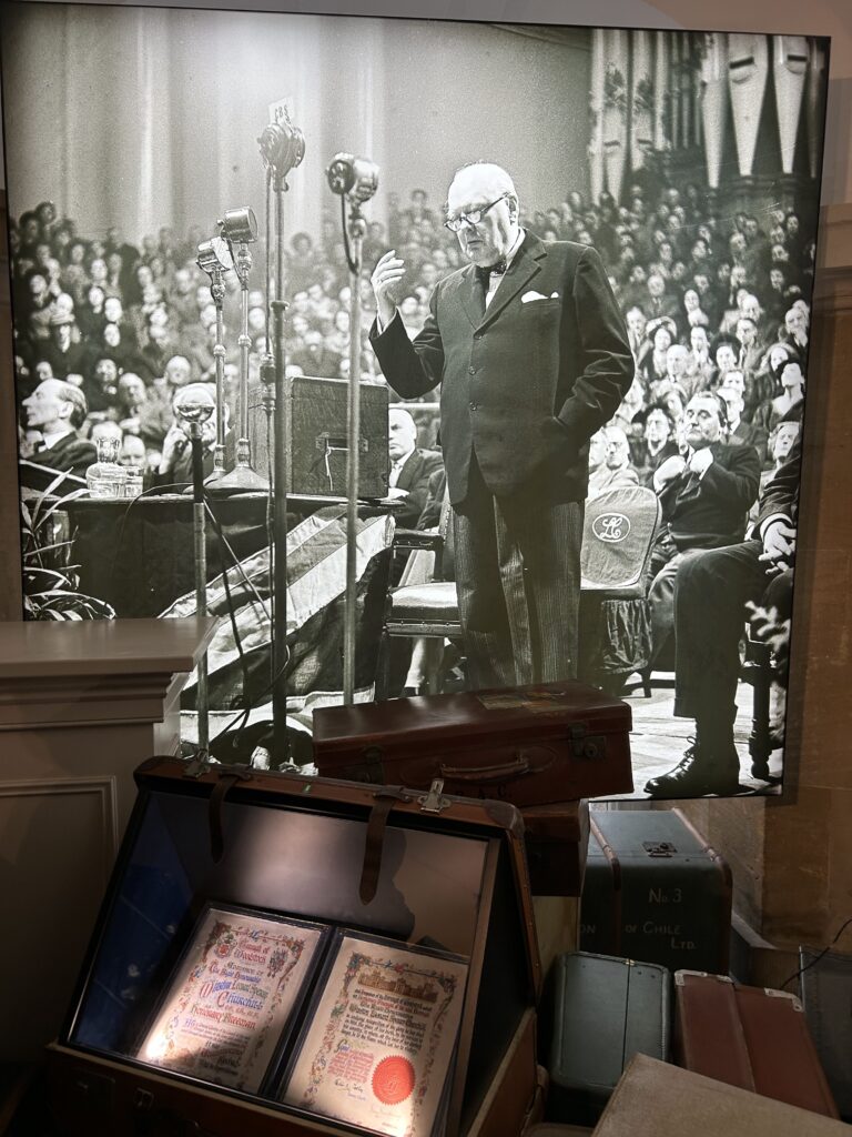 There is a permanent display on Winston Churchill, showcasing some of his personal effects as well as telling the story of his leadership especially during World War II. A large historical display of Sir Winston Churchill giving a speech behind personal artifacts and luggage in our Winston Churchill across England travel guide.