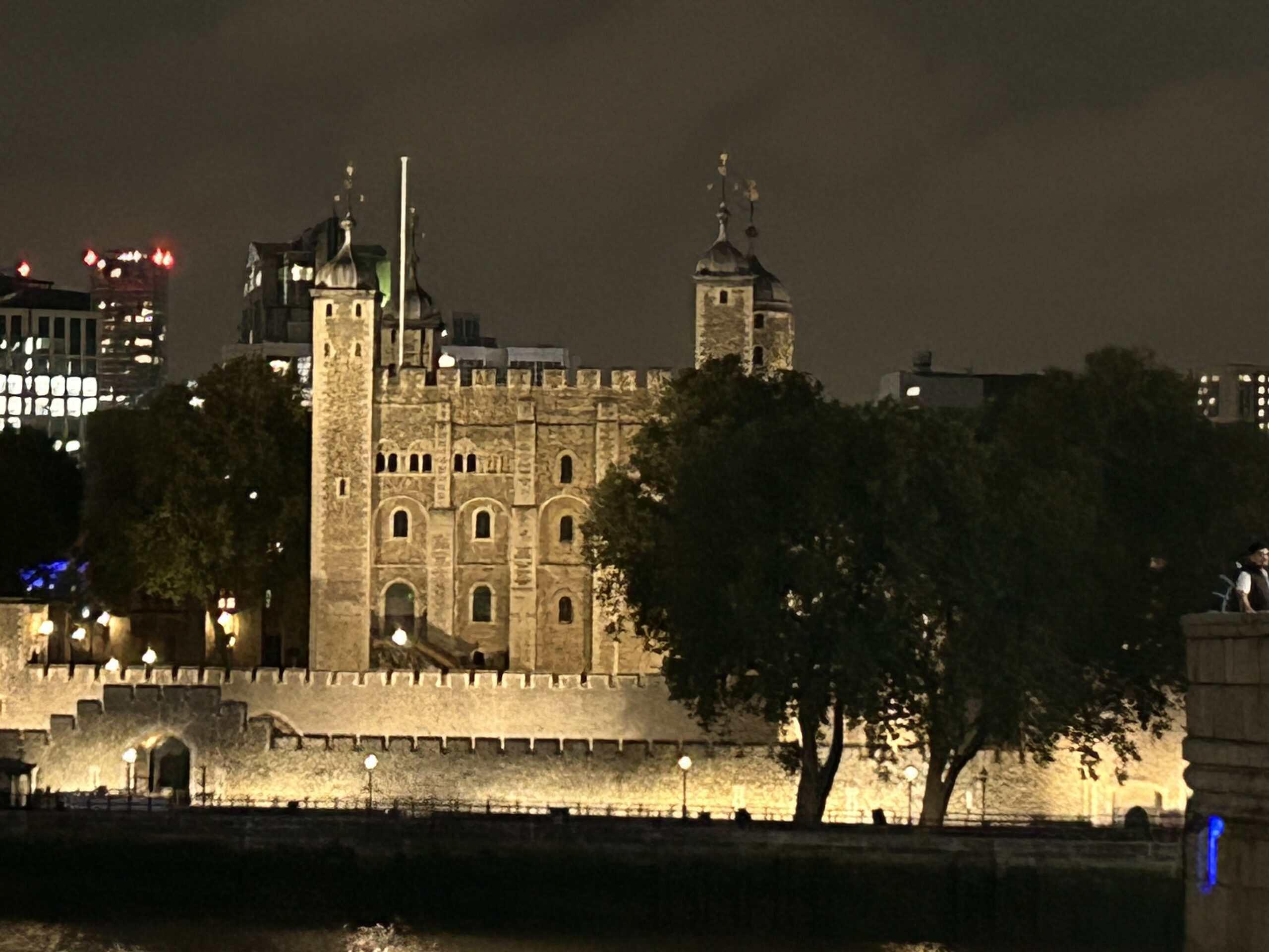 A dramatic nighttime view of the historic stone battlements at the Tower of London at night before the Ceremony of the Keys.