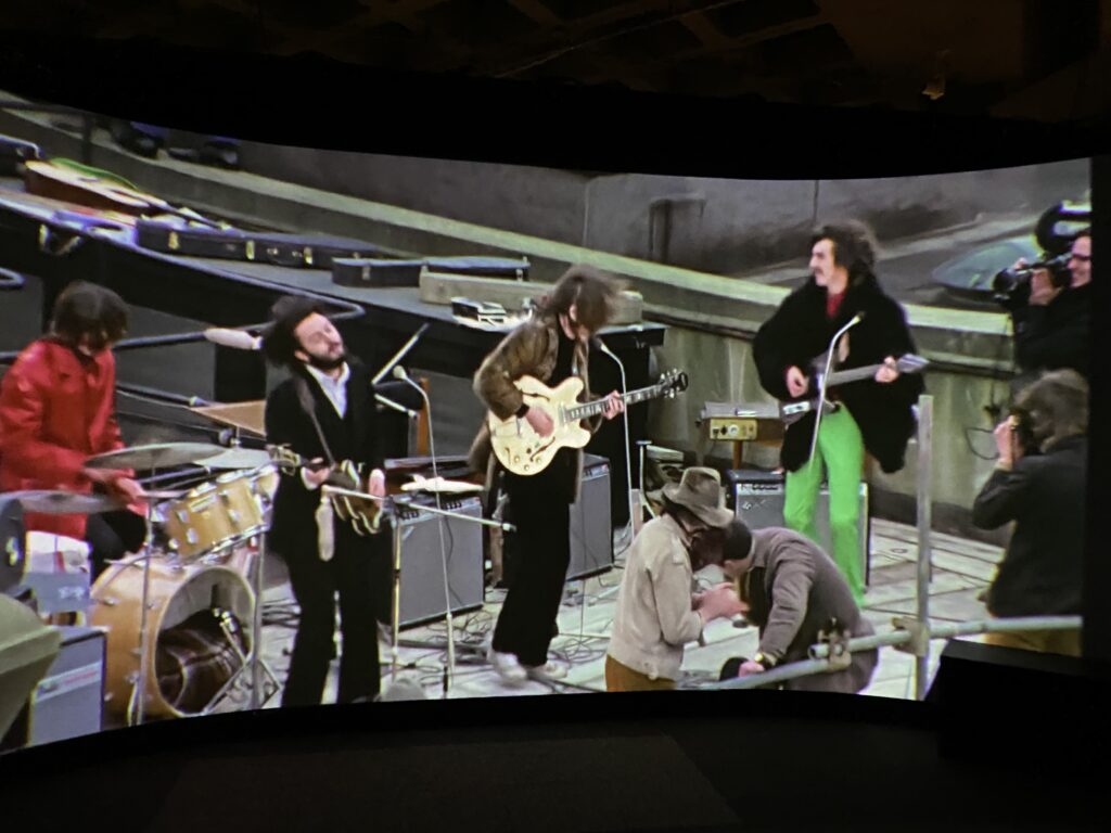 From an exhibit at the Rock N Roll Hall of Fame in Cleveland, a picture from the rooftop concert by the Beatles that many people would say was the end of the famed group. A museum display from the Rock & Roll Hall of Fame showcasing the iconic Beatles rooftop concert, featured in our Beatles breakup and Disney World history guide.