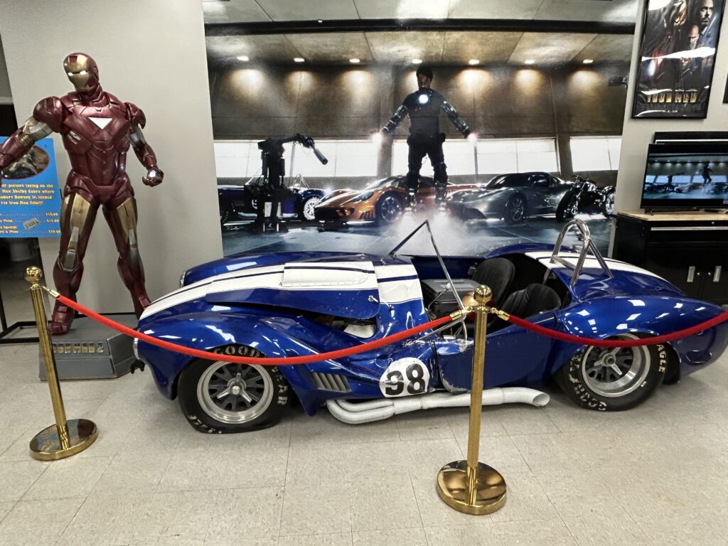 This damaged '65 Shelby Cobra might look familiar to Iron Man fans. This is the movie prop used in the original Iron Man movie, when Robert Downey Jr. was testing his suit and fell on the car. The damaged 1965 Shelby Cobra movie prop used in the original Iron Man film on display at the Hall of Heroes Elkhart Indiana.
