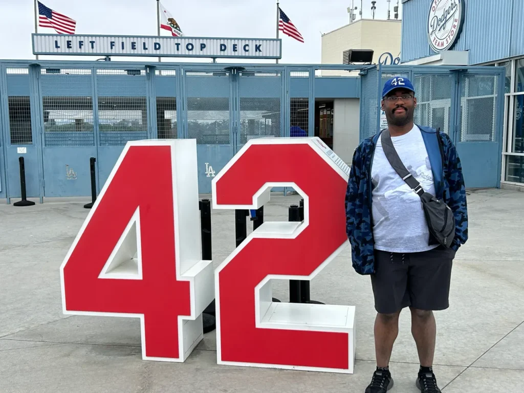Next to the gift shop are monuments of retired numbers for former Dodger greats including 42 for Jackie Robinson. Robinson's number 42 has been retired throughout baseball. A large outdoor monument of Jackie Robinson's retired number 42 near the Left Field Top Deck, showcasing a key moment in Dodger Stadium baseball history.