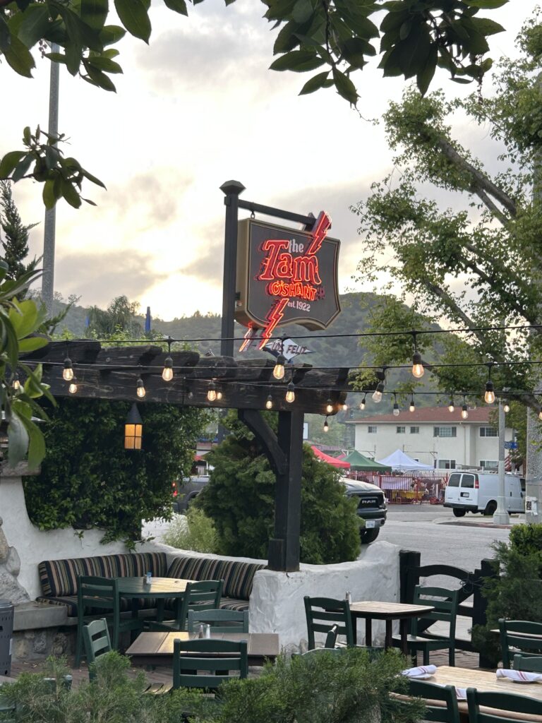 The iconic vintage neon sign and outdoor patio seating at the Tam O'Shanter Inn Los Angeles, a historic Scottish restaurant.