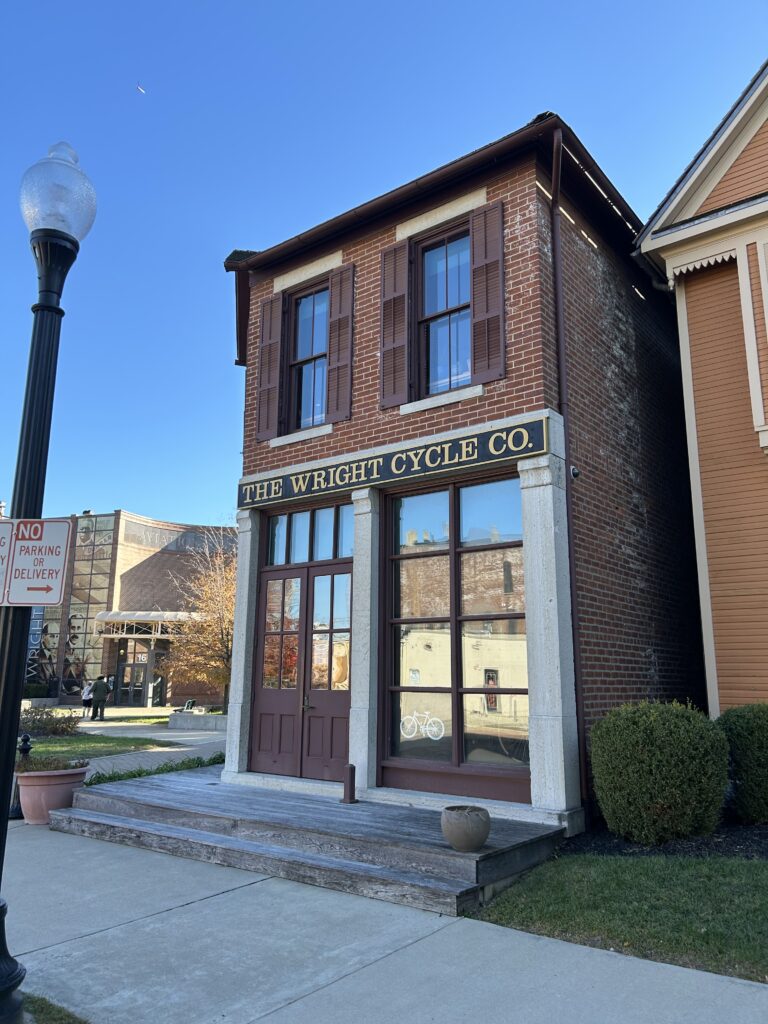 The brick exterior and gold lettering sign of The Wright Cycle Co. shop, a key landmark in Dayton Ohio aviation history.