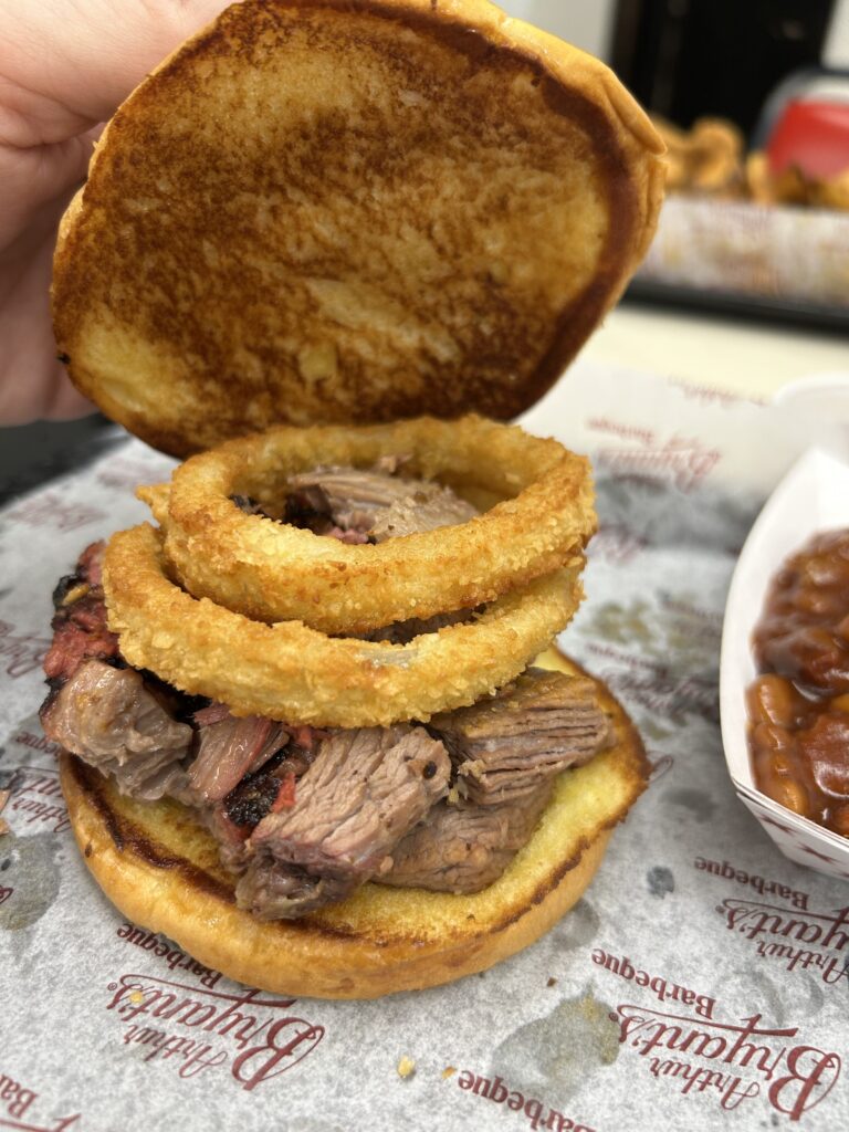 The 3B special, a burnt ends sandwich topped with an onion ring is one of the specialty sandwiches at Arthur Bryant's Barbeque in Kansas City. The legendary 3B sandwich featuring authentic, smoky burnt ends topped with a crispy onion ring on a Kansas City BBQ tour.