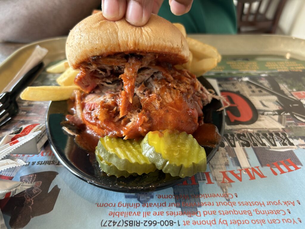 Pull pork sandwich with fries and pickles from Gates Bar-B-Q in Kansas City. A massive pulled pork sandwich served with French fries and pickles on a Kansas City BBQ tour.