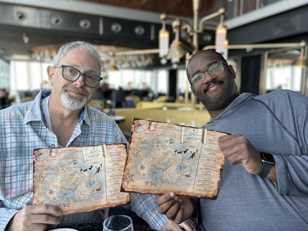 The Peter Pan theme is thoroughout the experience, including the treasure map menus. A guest holding the whimsical, custom-designed themed menu at the Peter Pan tea at The Shard.