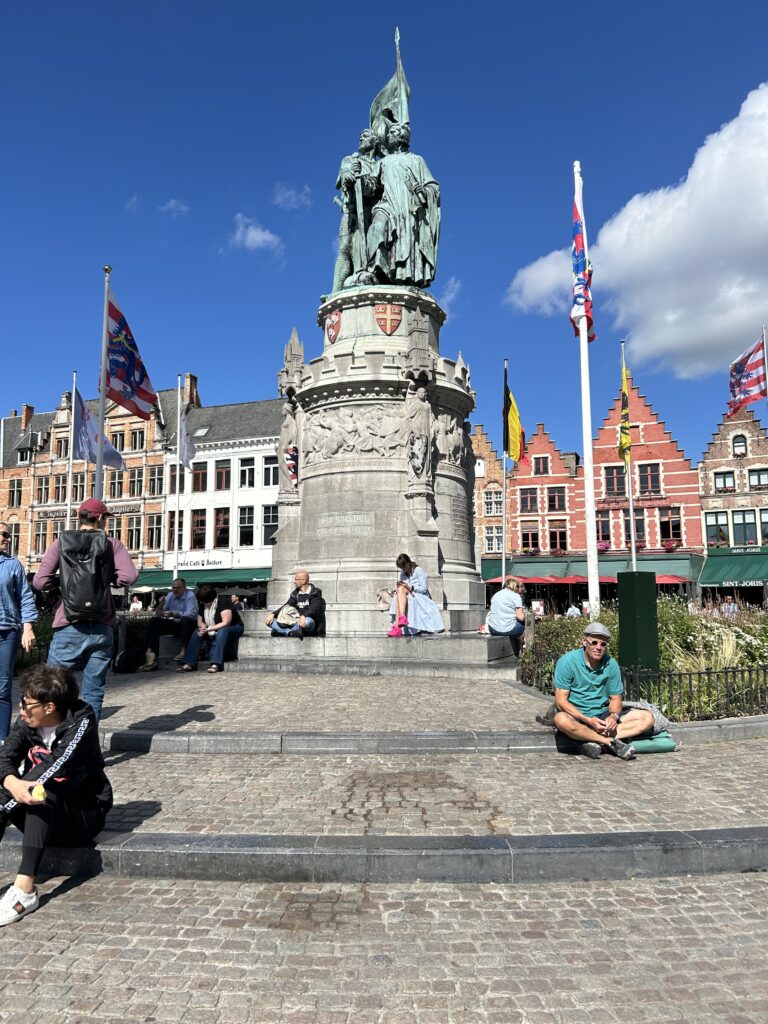 The bustling historic Markt Square and iconic Belfry tower during a Bruges day trip.