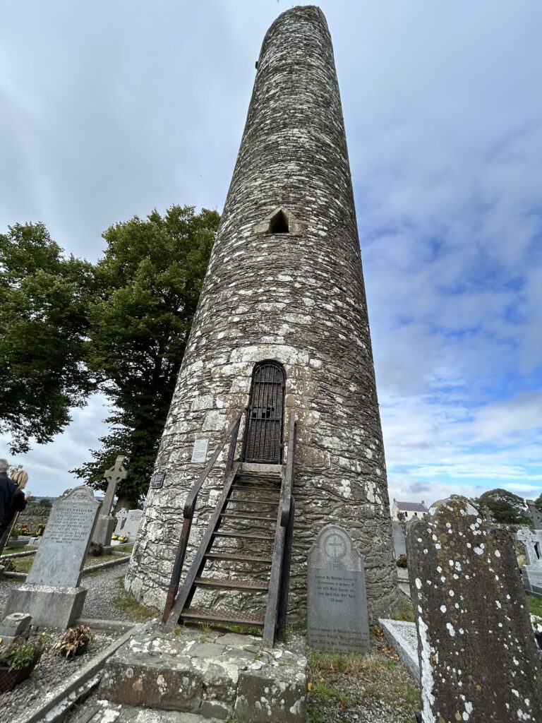 Round Tower at Monasterboice An ancient towering Celtic cross standing in the historic cemetery during a Monasterboice day trip Dublin.