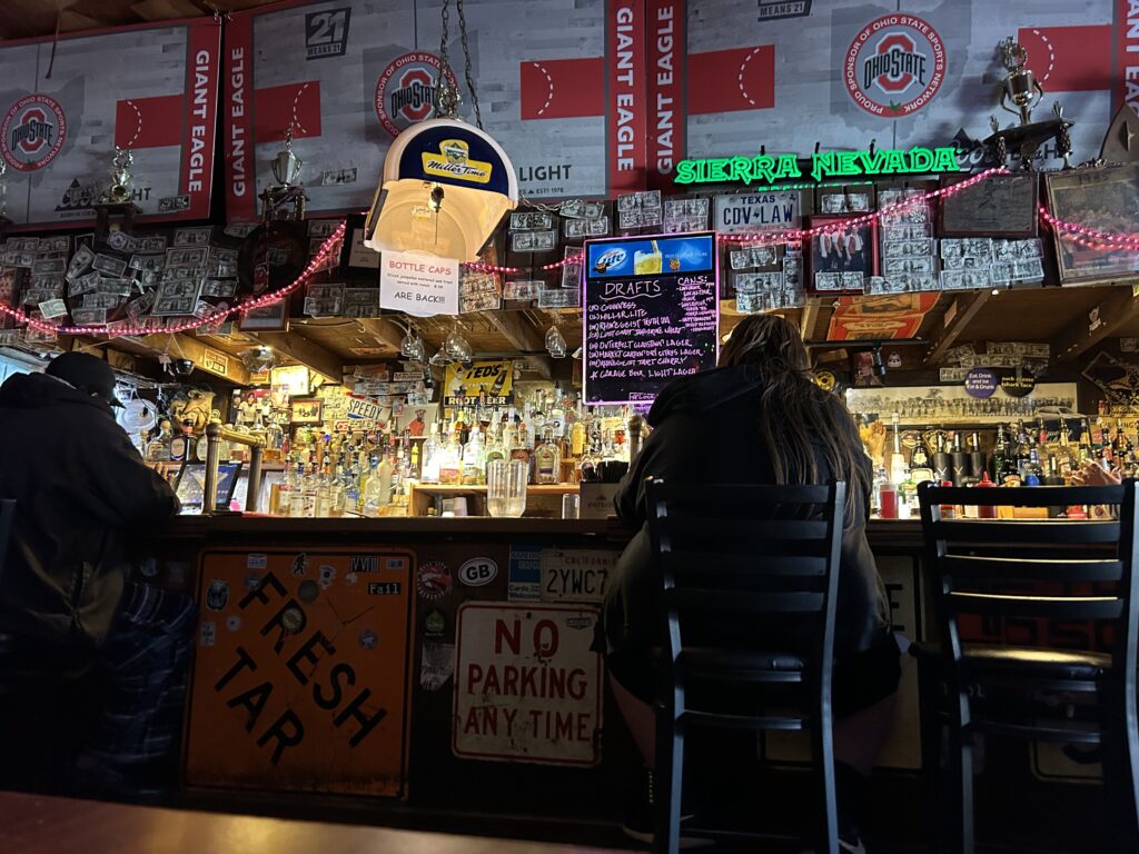 Thurman’s Cafe is a favorite for locals as well as fans coming to town for Ohio State football games. The bar is decorated from wall to wall with OSU support for the Buckeyes. A patron's perspective of the cozy main bar counter and tap handles inside the Thurman Cafe Columbus Ohio.