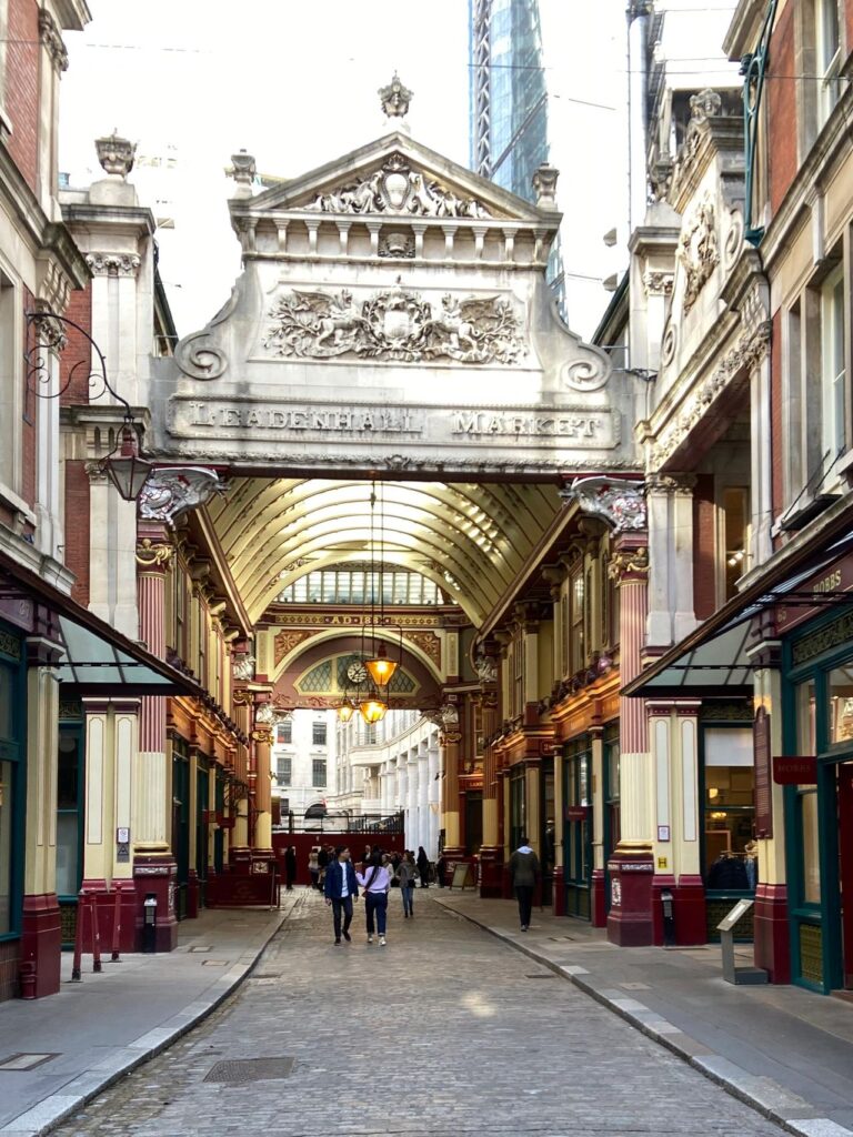 The ornate Victorian stone archway entrance to Leadenhall Market, a famous Diagon Alley filming location on the Harry Potter London black taxi tour.
