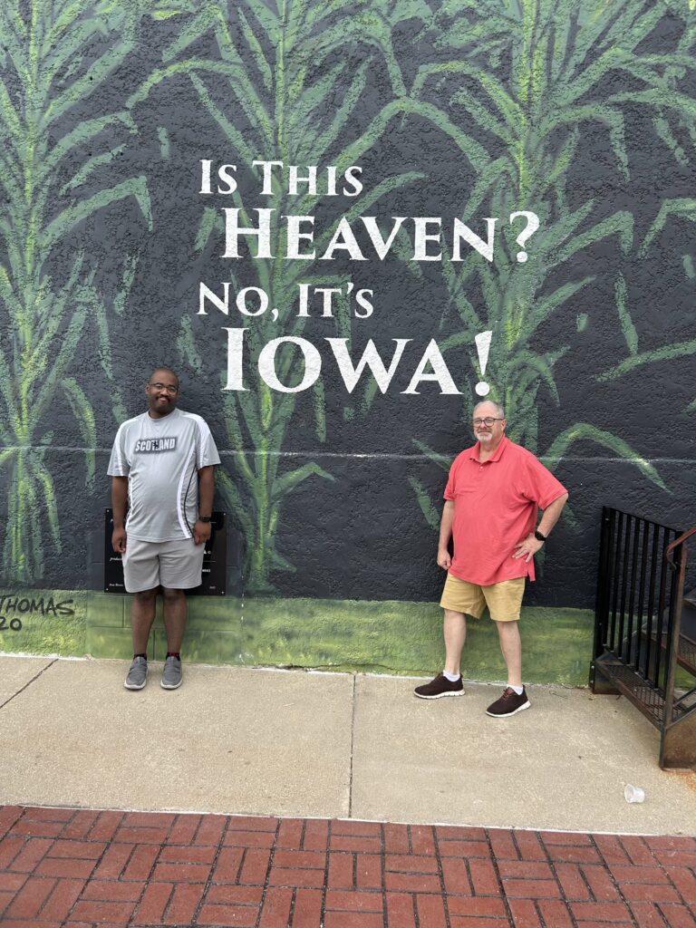 Baseball tourism guide Pete VanBaalen at Field of Dreams mural in Dyersville Iowa