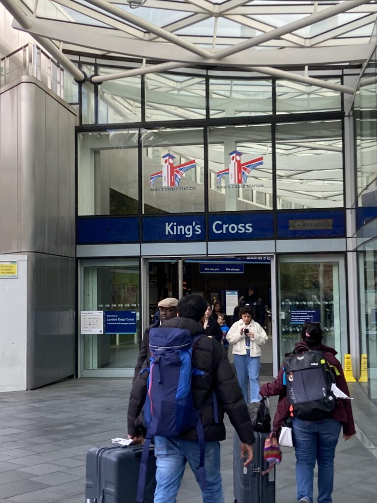 The iconic sign at the King's Cross London Underground station, a bustling transit hub featured in our London travel guide.