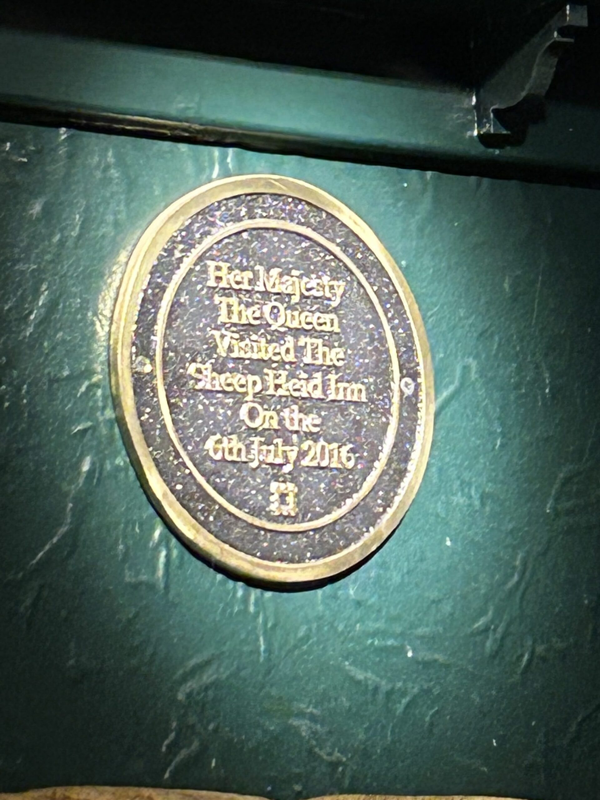 Proudly displayed in the dining area, this plaque honors the late Queen Elizabeth's visit in 2016. A close-up of the commemorative gold plaque honoring Her Majesty Queen Elizabeth II's historic 2016 visit to the Sheep Heid Inn Edinburgh.